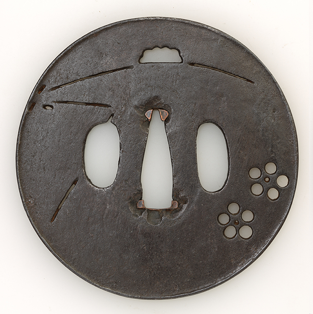 素材 鉄
形　丸
櫃孔　両櫃孔
技法磨地 陰透　打返耳

特徴 鍛えの良い滑らかな鉄板鐔を浅い鑢掛けとし、雪持ち松葉に梅花の小透かしを施した鐔です。薄手の造込みに透かしを入れることで鐔として強度に問題が生じるのを、打ち返し耳の技法により回避する構造になっています。光を通すと耳際にまで点状に入れた透かしが効いています。